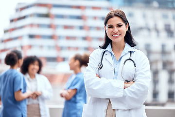 Image showing Woman, doctor and happy portrait outdoor with arms crossed at hospital, clinic or colleagues on rooftop for a break., Surgeon, smile and confidence on balcony and working in healthcare and medicine