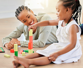 Image showing Family on the floor, mother and girl with blocks, playful and fun with happiness, weekend break and relaxing. Mama, apartment and kid with child development, home and building tower with wooden toys