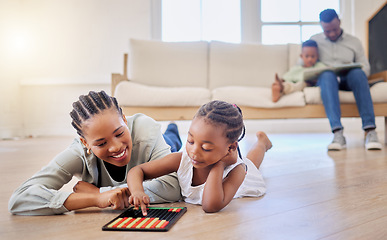 Image showing Education, smile and black woman playing with kid on the floor in the living room at modern home. Abacus, mathematics and young African mother helping girl child with counting at house together.