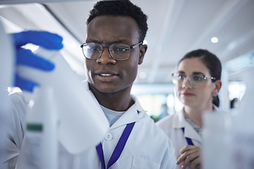 Image showing People, scientist or checking inventory in lab for experiment, sample bottle or chemical. Young man and woman or team in science research, stock check or reading product information at laboratory