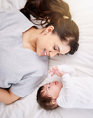 Image showing Mother, baby and bed with love and care or security with smile or bond in comfort and peace. A woman or mom and infant child in a bedroom for safety in a family home for growth, above and connection