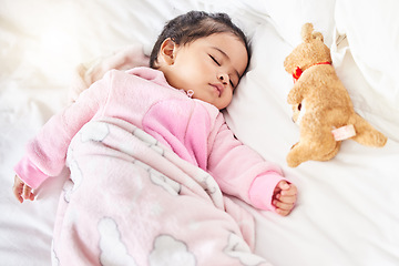 Image showing Baby, sleeping and girl in bed with teddy bear, animal and peace in home with blanket and comfort. Child, rest and sleep in morning, nap and routine for health, wellness and calm face of infant