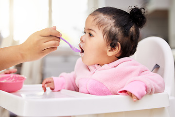 Image showing Hand, spoon and child food in chair for baby development, nutrition meal or dinner snack. Kid, feed and eating breakfast hungry for parent care or love for lunch together, diet vitamin in kitchen