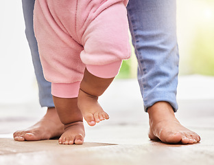 Image showing Mother, baby feet and walking with help and support or care with milestone and first steps. A woman parent and girl child walk barefeet with a mom for development in a family home for growth and love