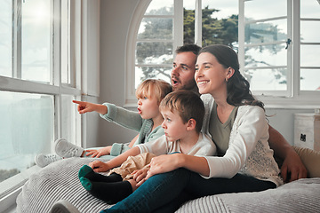 Image showing Parents, children and relax by window, happy and pointing with view, bonding and love with in family house. Father, mother and kids with conversation, talking and smile on bean bag, wow face and home