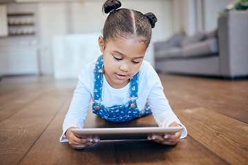 Image showing Kid, little girl and tablet for streaming in home with internet for entertainment, learning or watching. Child, youth and lying on floor in living room with technology for online, cartoon or game