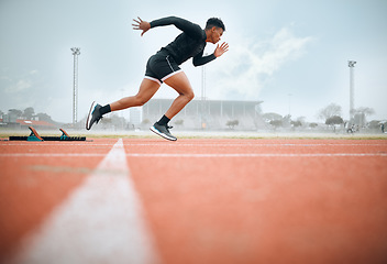 Image showing Man, athlete and ready for race on track with practice, training or exercise for competition. Black person, runner and fast with dedication, determination and passion on face with speed for sport