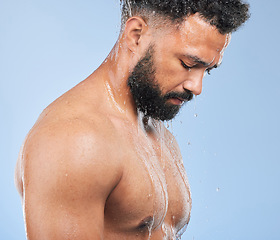 Image showing Shower, washing and man with water on blue background for cleaning, hygiene and skincare in studio. Dermatology, bathroom and person with splash, drops and cosmetics for wellness, health or self care