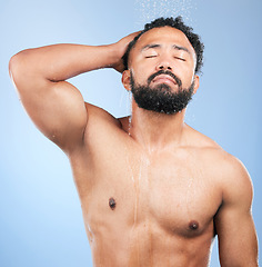 Image showing Shower, cleaning and relax man with shampoo and calm from water, skincare and morning routine. Bathroom, cosmetics and male model in studio with blue background and dermatology for wellness and wash