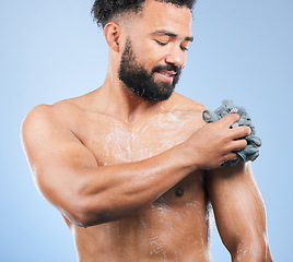 Image showing Shower, washing and man with sponge and soap for cleaning, hygiene and skincare on blue background. Dermatology, bathroom and person with splash, foam and cosmetics for wellness or health in studio