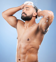 Image showing Shower, washing hair and man with foam in studio for cleaning, hygiene and skincare on blue background. Dermatology, bathroom and person with soap, shampoo and cosmetics for wellness and health