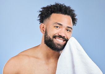 Image showing Shower towel, portrait smile and man with morning routine, facial cleaning or studio self care, wash and grooming. Bathroom, spa salon and model skin hygiene, wellness and dry face on blue background