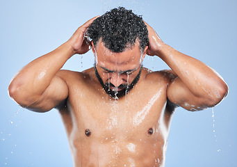 Image showing Shower, washing and man with water in studio for cleaning, hygiene and skincare on blue background. Dermatology, bathroom and person with splash, drops and cosmetics for wellness, health or self care
