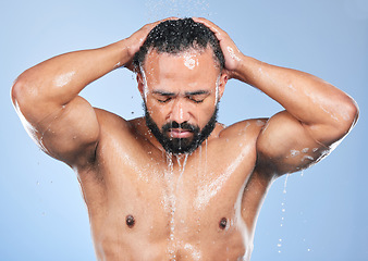 Image showing Shower, washing hair and man with water in studio for cleaning, hygiene and skincare on blue background. Dermatology, bathroom and person with drops or splash for wellness, grooming and self care