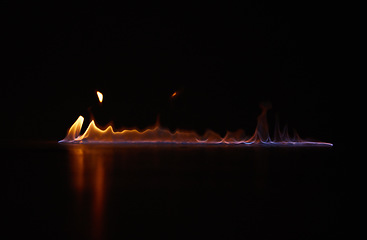 Image showing Flame, heat and gas fire with black background with sparks, smoke and light from burning in studio. Fuel, flare and glow from thermal power and art in the dark with creativity and inferno with burn