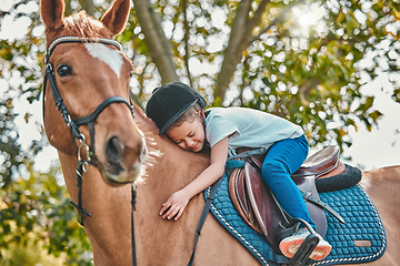 Image showing Love, nature and child hugging a horse in a forest riding for entertainment, fun or hobby activity. Adventure, animal and young equestrian girl kid embracing her stallion pet outdoor in the woods.