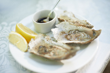 Image showing Background, food and plate of oysters in restaurant for lunch, dinner and eating appetizer of gourmet cuisine. Closeup, luxury seafood diner and serving of healthy shellfish dish on table with lemon