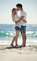 Image showing Couple, beach kiss and hug with love, support and care on a date by the sea with romance on vacation. Holiday, ocean and outdoor with summer travel in nature relax on a break and trip by the water