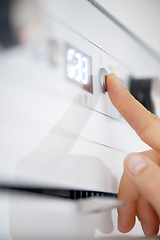 Image showing Closeup, finger and button on oven in kitchen for heating, preparation and appliance for baking. Person, press or switch with number display for setting, temperature and timer in home for cooking