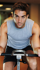 Image showing Man, exercise bike and fitness at gym, endurance and training for competition, sweat and cardio. Male person, cycling and determination in workout, motivation and machine for wellness, club or class