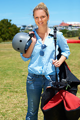 Image showing Skydiving, portrait and woman outdoor for adventure with gear and helmet in countryside with a smile. Happy, person and skydiver ready to start, stunt or risk danger with equipment for security