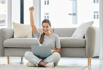 Image showing Winner woman, laptop and fist on floor for success, goal or bonus in trading, stock market or deal. Girl, computer and happy in home living room for cheers, invest or yes for profit, revenue or lotto