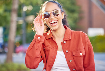 Image showing Woman, portrait and smile in city for travel in summer vacation, street explore or downtown. Female person, face and sunglasses for relax outdoor weekend or tourist in town, holiday walking on trip