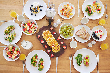 Image showing Table, breakfast and health with food, fruits and bread in home with plate, cutlery or salad. Above countertop, container or diet for nutrition with waffles, toast or juice for eating, drink and milk
