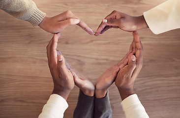 Image showing Business, collaboration and heart hands on a wooden background from above for love in the office. Team building, health and wellness with an employee group in the workplace together for unity