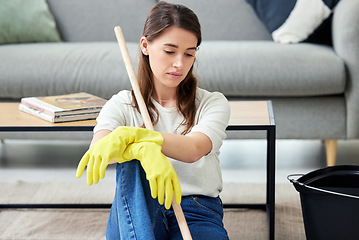 Image showing Cleaning, burnout and an unhappy woman in the living room of her home for housework chores. Sad, tired or exhausted with a young person looking bored in her apartment for housekeeping responsibility