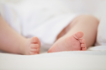 Image showing Sleeping, bed and feet of baby in home for dreaming, resting and nap for child development. Family, nursery and closeup of toes of newborn infant in bedroom relax for wellness, health and growth