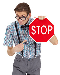 Image showing Portrait, stop sign and a man nerd pointing in studio isolated on a white background to direct traffic. Safety, law or legal with a young geek in glasses showing a road warning for speed danger