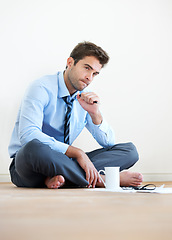 Image showing Stress, documents and thinking with a business man reading tax paper or a budget on the floor of his apartment. Accounting, finance and anxiety with a young employee looking worried about debt