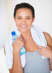 Image showing Happy woman, portrait and fitness with water bottle for hydration or natural nutrition at gym. Face of female person smile with mineral drink and towel for exercise, workout or training in wellness