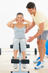 Image showing Happy woman, personal trainer and sit ups on bench at gym for workout, exercise or indoor training. Man, coach or instructor helping female person on equipment for strong core or abs at health club