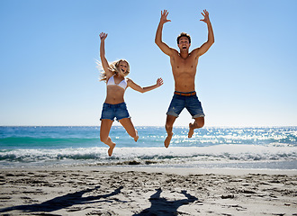 Image showing Couple, jump and excited at beach, smile and portrait in summer sunshine for vacation, outdoor or travel. Man, woman and happy with love, bonding and holiday by ocean for adventure in Naples, Italy