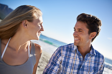 Image showing Couple, walk and smile on beach, talk and outdoor in summer sunshine for vacation, thinking or travel. Man, woman and happy with love, bonding and holiday by ocean for adventure in Naples, Italy