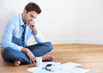 Image showing Stress, documents and finance with a business man reading tax paper or a budget on the floor of his apartment. Accounting, compliance and anxiety with a young employee looking worried about debt