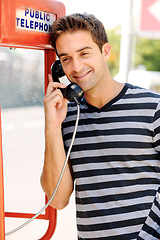 Image showing Telephone, happy and man in city by booth for communication, phone call and contact. Fashion, payphone and person in urban town for talking, speaking and conversation in trendy clothes and style