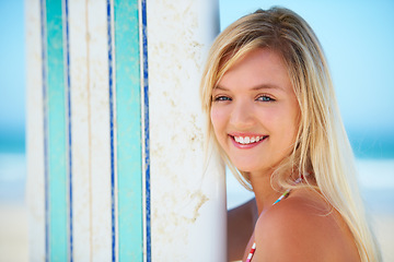 Image showing Surf, board and portrait of woman at beach with smile in summer, vacation or holiday with fun sport. Person, face and happiness outdoor in sunshine with blue sky at ocean, water or travel at sea