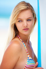 Image showing Surf, board and woman at beach thinking about summer, vacation and bikini for holiday. Serious, face and person outdoor in sunshine offshore with confidence and ideas for watersports and travel