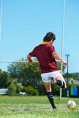 Image showing Back, kick and man playing with rugby ball on a grass field to score during workout. Athlete, sport and professional player training for healthy workout in a uniform for kicking exercise with energy