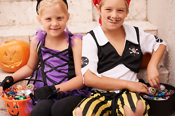 Image showing Siblings, portrait and halloween costume on stairs, candy and happiness in childhood. Boy, girl or smile face for holiday party event with trick or treat, theme clothes fairy or pirate by backyard