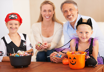 Image showing Happy family, portrait and halloween party in home, trick or treat and happiness in childhood. Man, woman and kids for holiday with candy, pumpkin and fairy costumes for love and celebration in house
