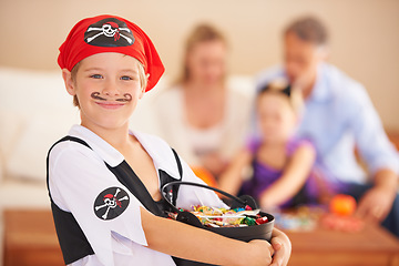 Image showing Boy, portrait or candy for halloween in home, face paint or happiness in childhood. Son, chocolates and family on holiday for trick o treat, pirate costume and love in celebration together in house