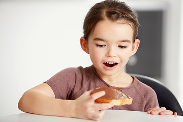 Image showing Little girl, toast and chocolate spread for sweet, delicious or desert snack on bread in kitchen at home. Young female person, child or kid in surprise for food or candy treat on wheat at house