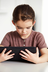 Image showing Little girl, tablet and watching on table in living room for online entertainment, games or research at home. Female person, child or kid with technology for communication or networking at house