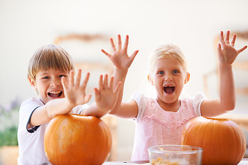 Image showing Halloween, hands and carving a pumpkin with children at a home table for fun and bonding. Boy and girl or young kids as siblings together for creativity, holiday lantern and portrait or play in house