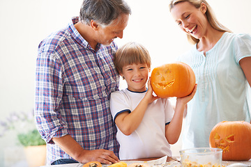 Image showing Halloween, family and carving a pumpkin with a child in a home for fun and bonding. Man and woman or parents and young kid for portrait together for creativity, holiday lantern and happy craft