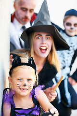 Image showing Portrait, halloween and a family in costume for fantasy tradition or holiday celebration. Mother, father and children at a door in trick or treat clothes for dress up on allhallows eve together
